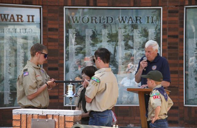 Terry Walters (right) reads from a list of veterans who have passed in the last year while Troop 779 tolls the bell for each name.